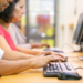Profissionais utilizam computadores em ambiente de trabalho para realizar tarefas de informática.