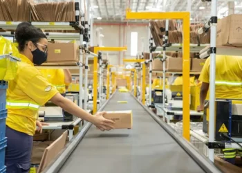 Funcionários do Mercado Livre atuam em centro logístico durante operação de separação e distribuição de mercadorias.