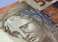 Notas de dinheiro brasileiro representando o pagamento mensal de R$ 700 do Pé-de-Meia Licenciaturas.