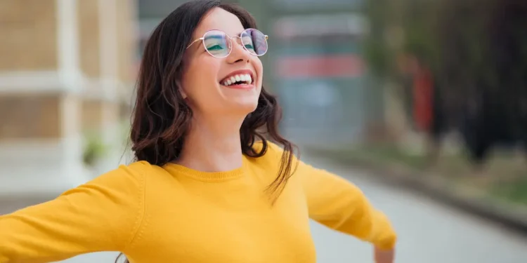 Mulher sorrindo ao ar livre representa resiliência mental e equilíbrio emocional.