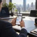 Pessoa utilizando o LinkedIn pelo celular em ambiente corporativo, representando a importância de manter o perfil profissional atualizado para buscar oportunidades de estágio.