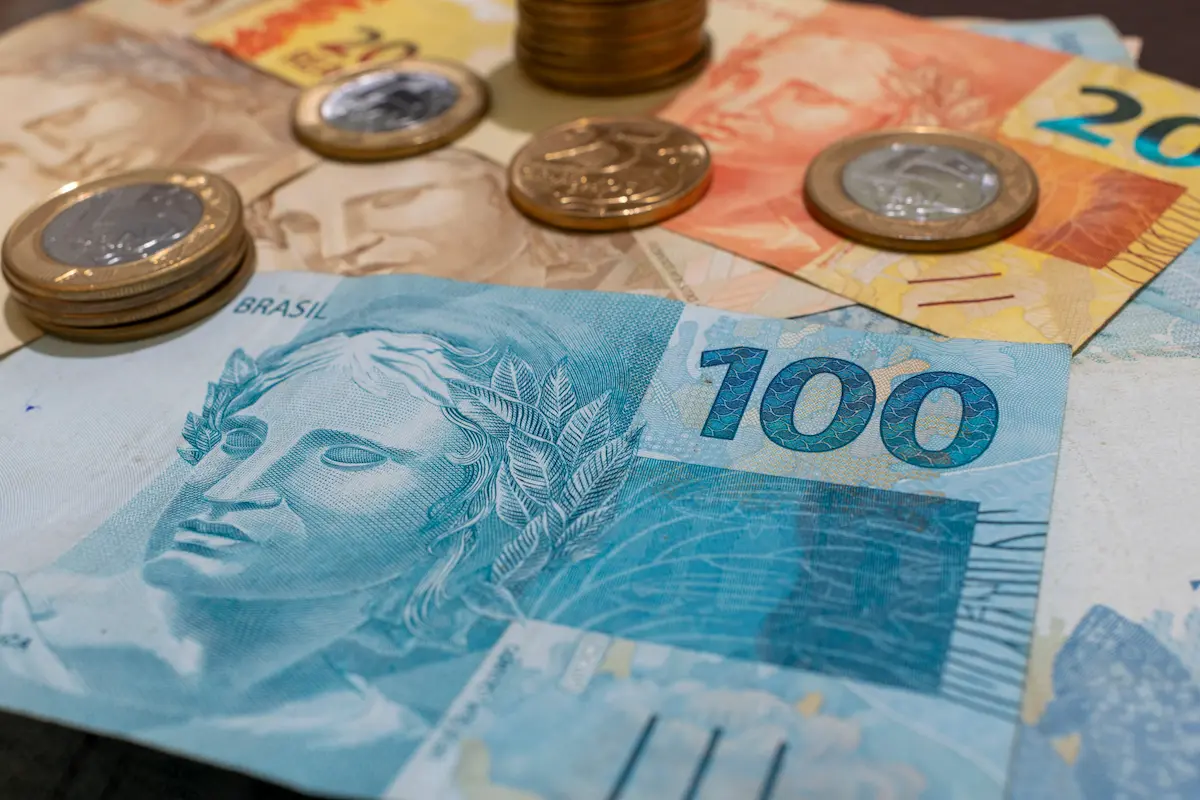 Cédulas de dinheiro brasileiro e moedas representam a definição do valor correto de remuneração do trabalhador.