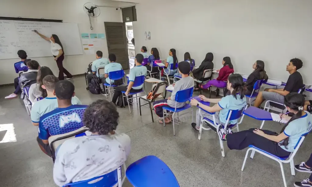 Professora em sala de aula durante atividade de ensino com estudantes.