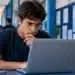 Aluno consulta informações em notebook, representando o acompanhamento da convocação da lista de espera do 2º semestre do Fies 2026.