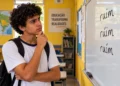 Estudante observa as formas "rúim" e "ruím" escritas no quadro durante aula de português