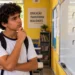 Estudante observa as formas "rúim" e "ruím" escritas no quadro durante aula de português