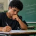 Estudante escrevendo a redação do Enem em sala de aula, representando a possível troca do modelo tradicional por textos mais curtos.