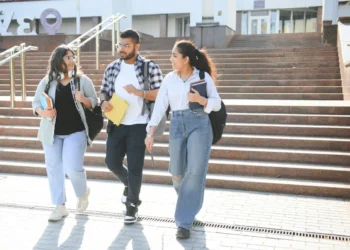 Imagem ilustrativa de estudantes universitários em frente a uma instituição.