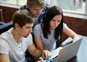 Estudantes participam de atividade acadêmica com notebook.