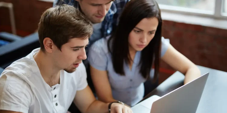 Estudantes participam de atividade acadêmica com notebook.
