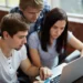 Estudantes participam de atividade acadêmica com notebook.