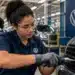 Estagiária da Volkswagen atua em linha de produção durante rotina profissional em fábrica da empresa.