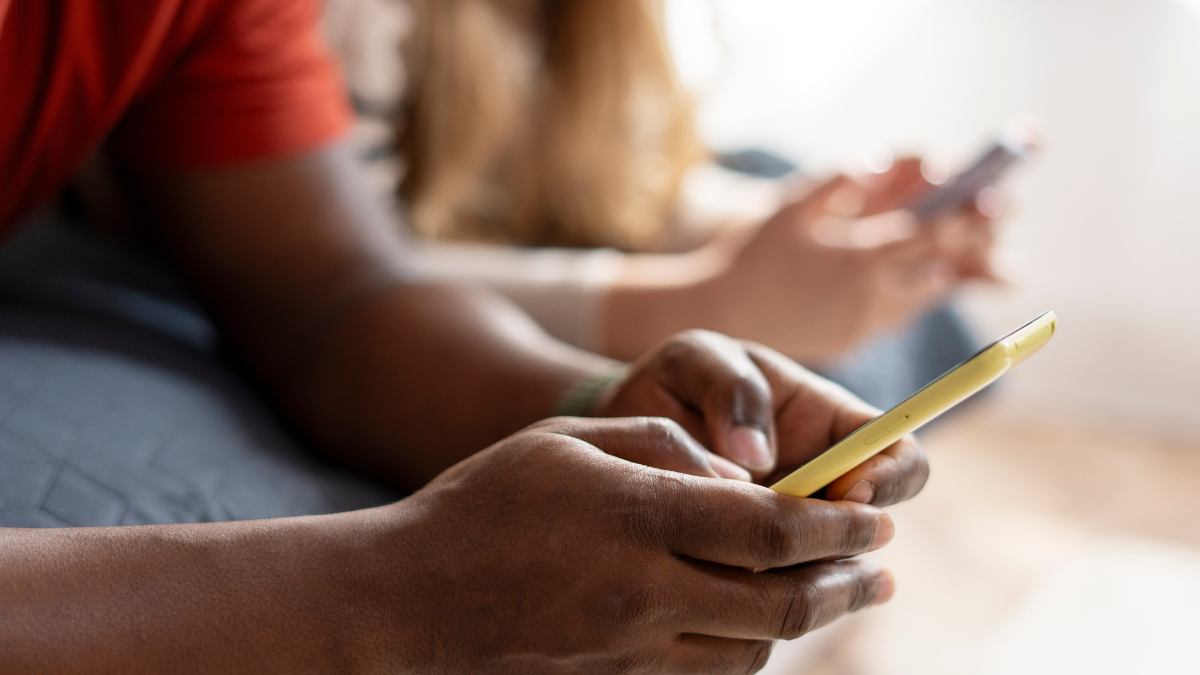 Adolescente utilizando celular, com destaque para medidas de verificação de idade em plataformas digitais.
