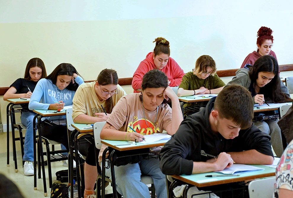 Imagem ilustrativa de candidatos fazendo prova em carteiras enfileiradas numa sala de aula, em referência ao vestibular Unicamp 2027