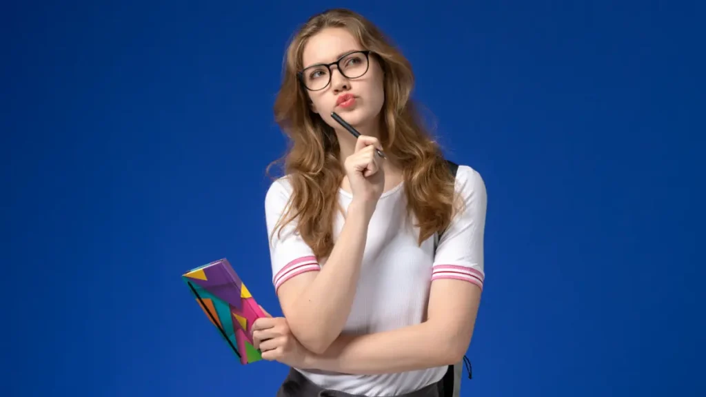 Jovem pensando com caderno colorido em fundo azul.