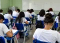 Estudantes em sala de aula realizam prova em ambiente escolar brasileiro.