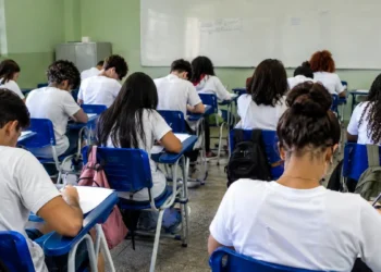 Estudantes em sala de aula realizam prova em ambiente escolar brasileiro.