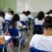 Estudantes em sala de aula realizam prova em ambiente escolar brasileiro.