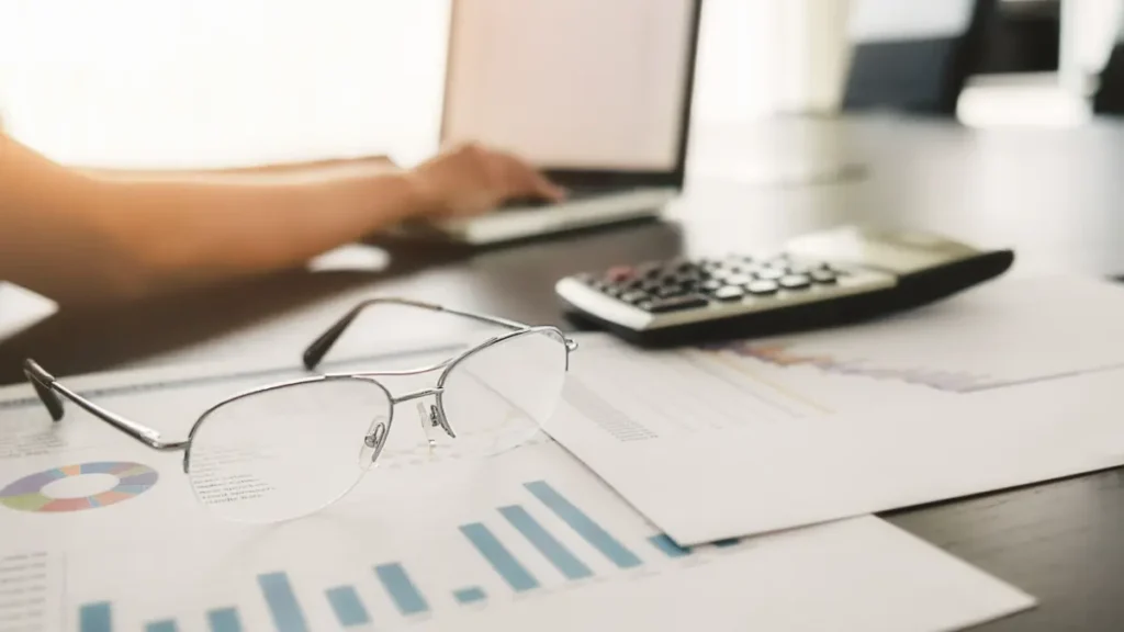 Análise financeira em escritório com gráficos e calculadora.