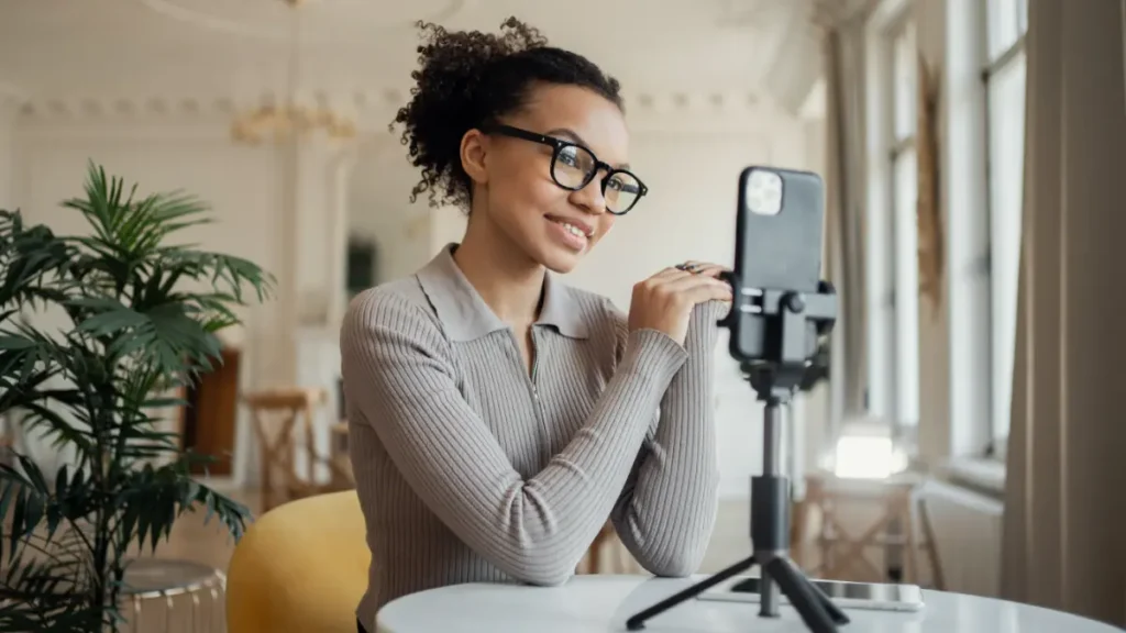 Jovem gravando vídeo em ambiente iluminado para redes sociais.