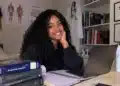 Jovem sorrindo em ambiente de estudos.