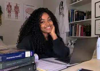 Jovem sorrindo em ambiente de estudos.