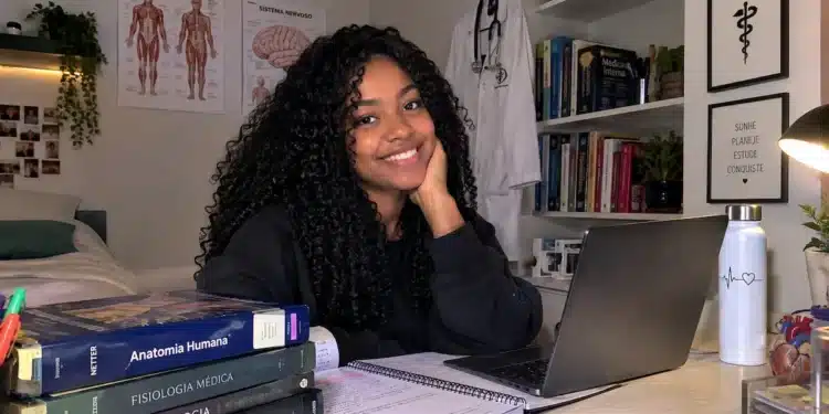 Jovem sorrindo em ambiente de estudos.