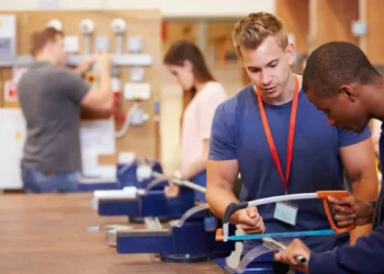 Alunos praticando aula técnica de serralheria com orientação em laboratório.