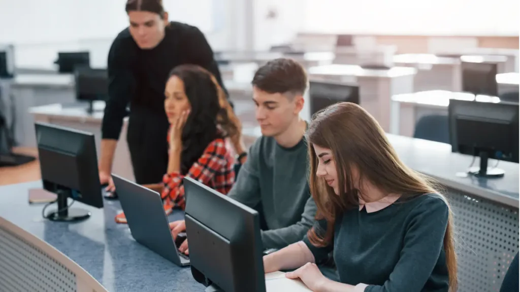 Jovens estudando em laboratório de informática.