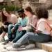 Estudantes universitários conversam em escadaria de campus ao ar livre.