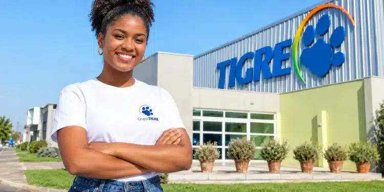 Colaboradora sorridente em frente à sede do Grupo Tigre.