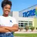Colaboradora sorridente em frente à sede do Grupo Tigre.