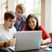 Jovens colaboram em projeto digital estudantil em ambiente iluminado.