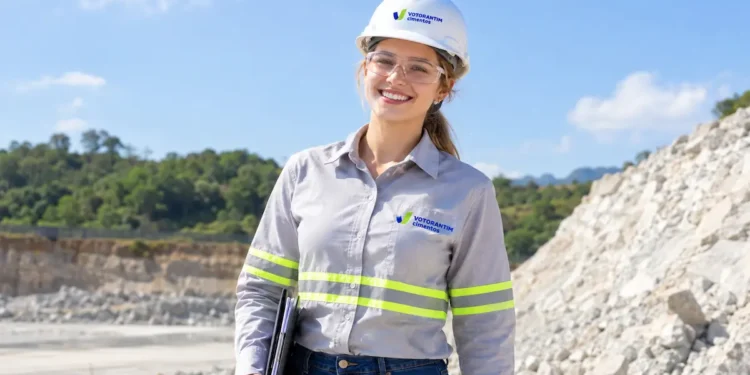Engenheira da Votorantim Cimentos em área de mineração ao ar livre.