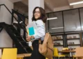 Jovem estudante sorridente com mochila em biblioteca moderna.