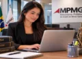Mulher digitando em laptop no escritório do MPMG com livros de Direito e estátua da Justiça, simbolizando o estágio no MPMG.