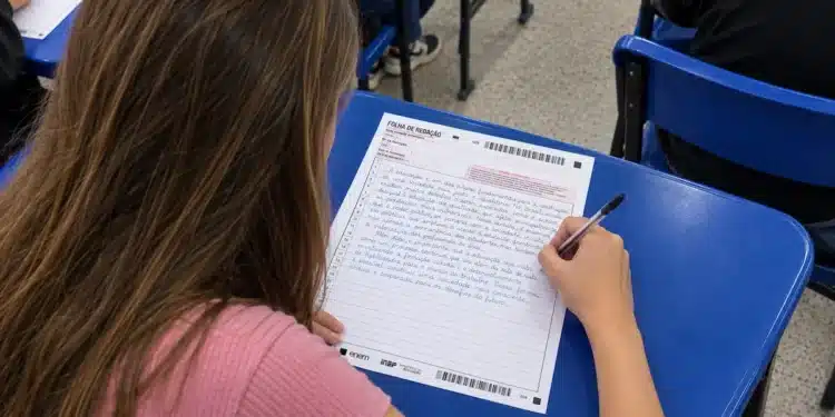 Estudante escrevendo a redação do Enem na folha de redação durante a prova.
