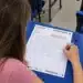 Estudante escrevendo a redação do Enem na folha de redação durante a prova.