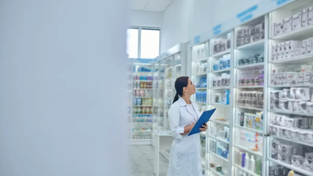 Farmacêutica realiza conferência de estoque em farmácia moderna.