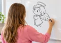 Jovem desenha um anjo no quadro branco em ambiente claro.