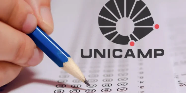Mão segurando lápis azul preenche cartão-resposta ao lado do logotipo da Unicamp.