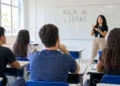 Jovens assistem à aula de Libras em uma sala iluminada.