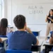 Jovens assistem à aula de Libras em uma sala iluminada.
