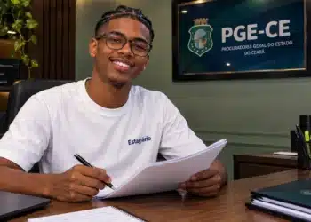 Estagiário trabalhando na PGE-CE em ambiente administrativo moderno.