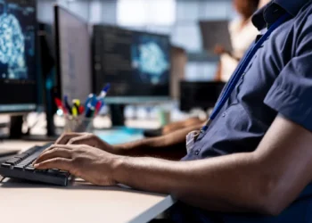 Pesquisador utiliza computador em ambiente de estudos de pós-graduação em Ciência da Computação.