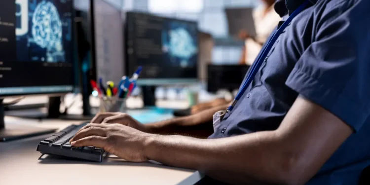 Pesquisador utiliza computador em ambiente de estudos de pós-graduação em Ciência da Computação.