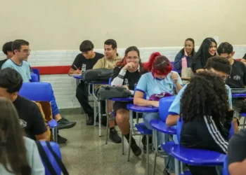 Estudantes interagem em sala de aula no ensino médio público brasileiro.