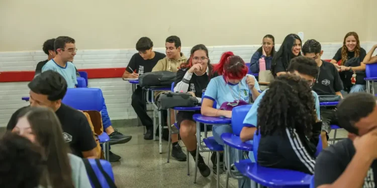 Estudantes interagem em sala de aula no ensino médio público brasileiro.