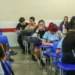 Estudantes interagem em sala de aula no ensino médio público brasileiro.