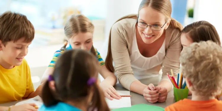 Professora interagindo com crianças em atividade escolar.